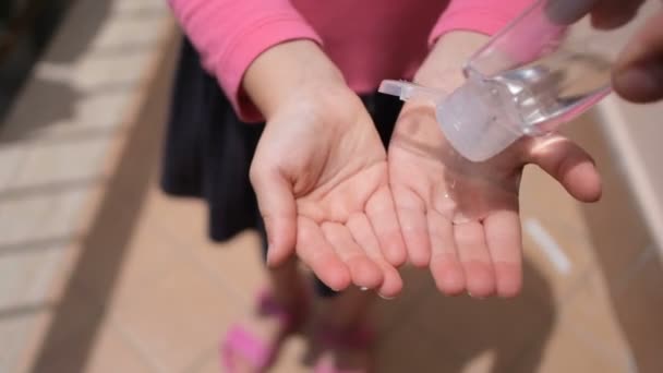 Mężczyzna dezynfekować małą dziewczynkę alchoolowym środkiem dezynfekującym do rąk, chorobą koronawirusową — Wideo stockowe