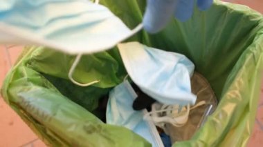 Çöp tenekesinde kullanıldıktan sonra çöpe atılan tıbbi koronavirüs atıkları, kovid19 hastalığı, kirli maske ve tek kullanımlık eldivenler.