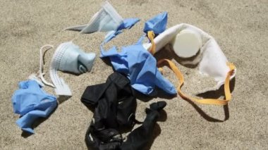 Maske ve plastik eldiven, deniz kıyısındaki tıbbi çöpler, koronavirüs kirliliği