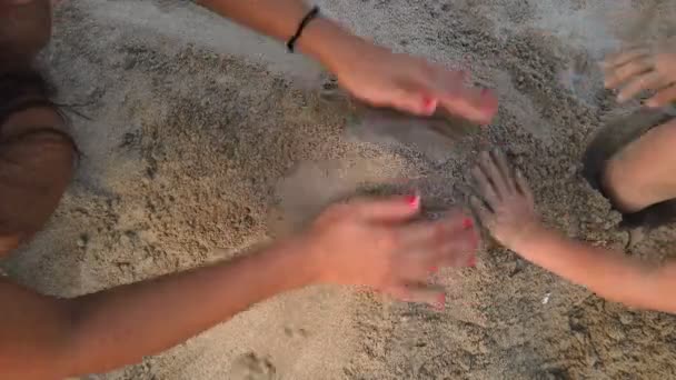 Madre e hija jugando con arena en la playa del mar, las manos cerca, los niños de la familia — Vídeos de Stock