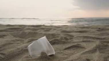 İnsanlar deniz kıyısında plastik cam çöpleri toplar, ekosistem kirliliğini temizler, 4K