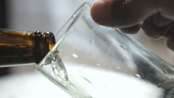 Close up view of man puoring beer from bottle into a glass mug,alcohol addiction — Stock Video