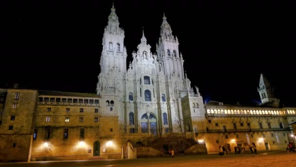 Pessoas andando na velha catedral de Santiago de Compostela Praça Obradoiro à noite, estilo de vida da cidade timelapse 4k — Vídeo de Stock