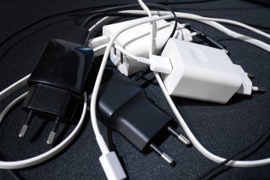 Siyah yüzeye yüklenmiş akıllı telefon yığını, teknoloji. 