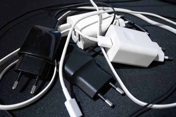 Siyah yüzeye yüklenmiş akıllı telefon yığını, teknoloji. 