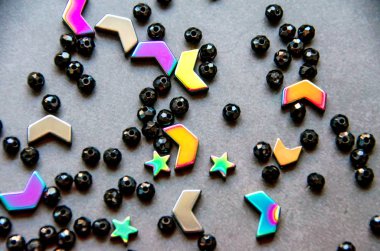 Beyaz ve gri arka planda izole renkli, siyah boncuklar ve taşlar