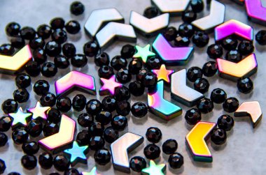 Beyaz ve gri arka planda izole renkli, siyah boncuklar ve taşlar