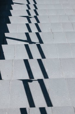 Gri merdiven aşağı gidiyor, korkuluk gölge ile