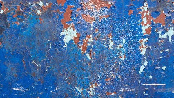 Blue painted metal background, with many cracks, peeling and flaking paint. Rusted texture