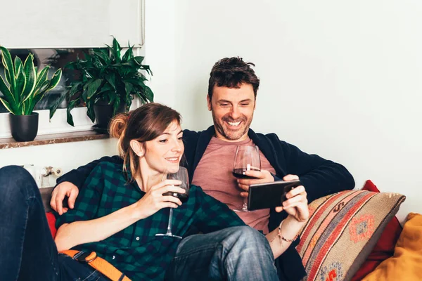 Feliz Casal Amor Beber Vinho Tinto Olhando Para Smartphone Relaxando — Fotografia de Stock