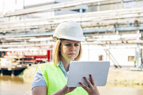 bir tablet tutan bir fabrikada kadın işçi açık havada. kadın meslekleri ve endüstriyel işler kavramı