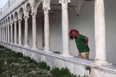 bir at baş maskesi ile adam hayatını düşünürken eski bir manastır altında bir sütun yaslanıyor. Sorunlar, kişilik, mistisizm, düşünceler, yaşam kavramı