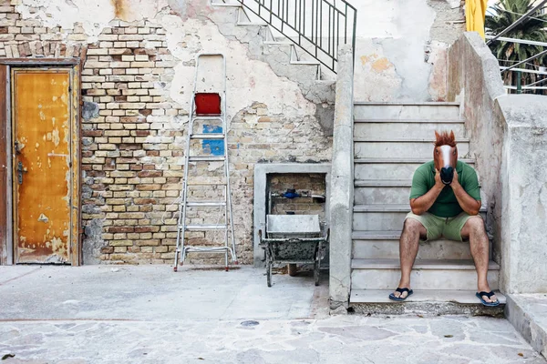 atlı kamu sokakta bir merdiven üzerinde oturur, onun önünde bakarak, o zaman yavaş akmasına izin verir