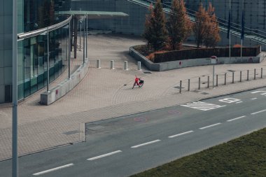boş bir sokakta bir binanın dışında park edilmiş kırmızı bir elektrikli bisiklet araba trafiğine kapalı. Yeni kentsel hareketlilik simgesi. Yeşil ve teknoloji taşımacılığı konsepti