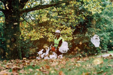 Plastic bags fly everywhere during the cleaning of an urban park. clipart