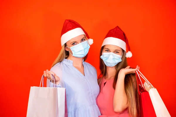 Amigas Con Máscara Quirúrgica Sombrero Navidad Sosteniendo Bolsas Compras Sobre —  Fotos de Stock