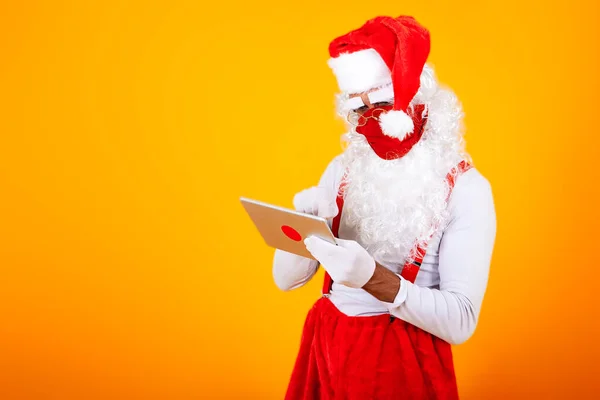 Papá Noel Moderno Con Una Máscara Facial Una Tableta —  Fotos de Stock