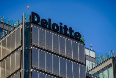 Bükreş, Romanya - 12 Mayıs 2020: İngiliz denetim & güvence logosu, danışmanlık, mali danışmanlık, risk danışmanlığı, vergi ve ilgili hizmetler Deloitte Bükreş 'teki bir binanın tepesinde görülüyor.