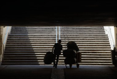 Bükreş, Romanya - 09 Nisan 2020: Bükreş 'teki Latin Geçidi' nden bir mağaza için büyük çantalar dolusu mal taşıyan bir adam.