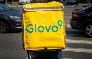 Bükreş, Romanya - 25 Haziran 2020: Bir Glovo gıda dağıtım kuryesi Romanya 'nın Bükreş kentinde gıda dağıtıyor.