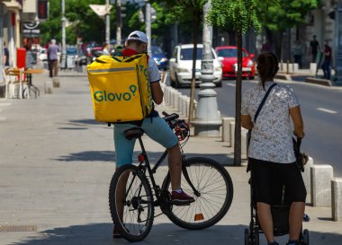 Bükreş, Romanya - 30 Haziran 2020: Bir Glovo gıda dağıtım kuryesi Romanya 'nın Bükreş kentinde gıda dağıtıyor.
