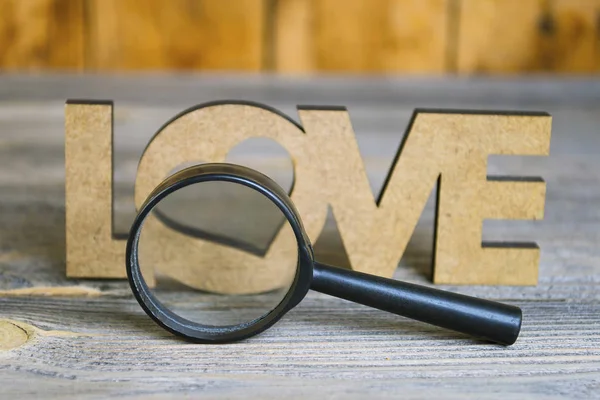 abstraction view love through a magnifier on an old wooden background