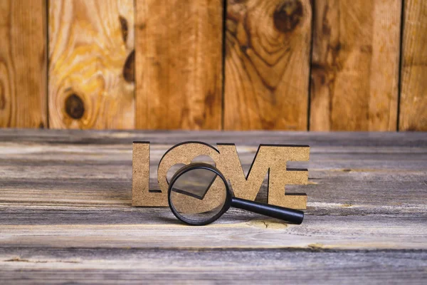 abstraction view love through a magnifier on an old wooden background