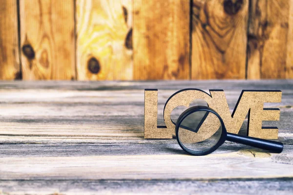 abstraction view love through a magnifier on an old wooden background