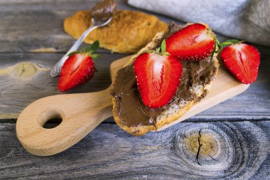 kruvasan çikolata makarna ve eski bir ahşap zemin üzerine çilek ile