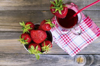 çilek suyu ve ahşap arka plan üzerinde bir cam fincan taze çilek