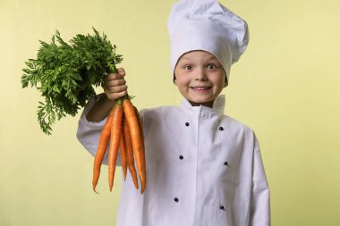 komik çocuk Şef elinde büyük bir havuç tutar.