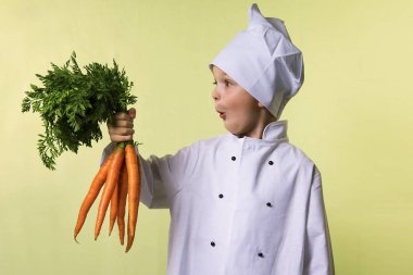 komik çocuk Şef elinde büyük bir havuç tutar.