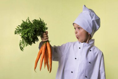 komik çocuk Şef elinde büyük bir havuç tutar.