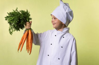 komik çocuk Şef elinde büyük bir havuç tutar.