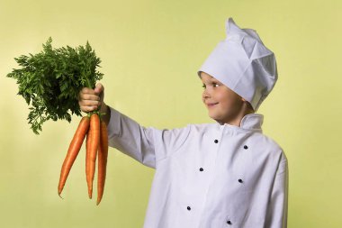 komik çocuk Şef elinde büyük bir havuç tutar.