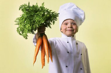 komik çocuk Şef elinde büyük bir havuç tutar.