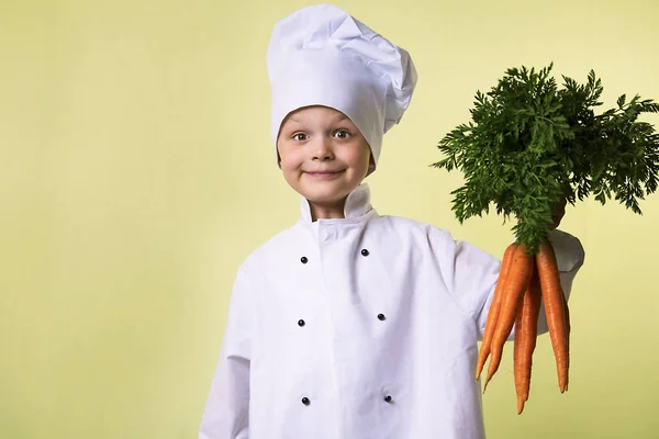 Divertente Ragazzo Chef Mantiene Nelle Sue Mani Una Grande Carota — Foto Stock