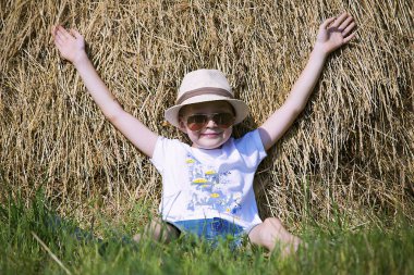 yaz alanında saman yığını ile mutlu sevimli çocuk