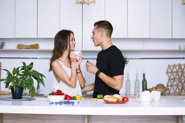 sevimli genç kadın ve erkekte tablo içinde ev yakınındaki beyaz mutfak