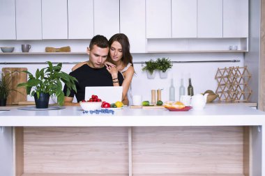 sevimli genç kadın ve erkekte tablo içinde ev yakınındaki beyaz mutfak
