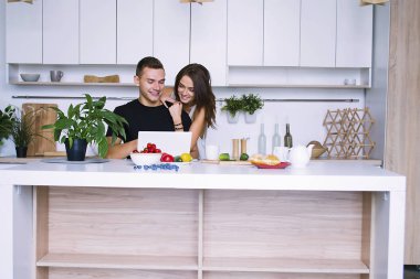 sevimli genç kadın ve erkekte tablo içinde ev yakınındaki beyaz mutfak