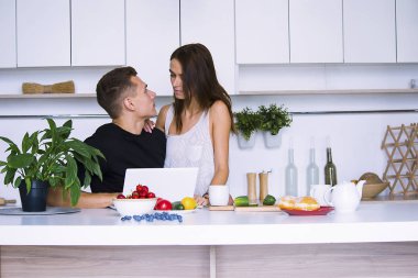 sevimli genç kadın ve erkekte tablo içinde ev yakınındaki beyaz mutfak