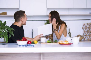 sevimli genç kadın ve erkekte tablo içinde ev yakınındaki beyaz mutfak