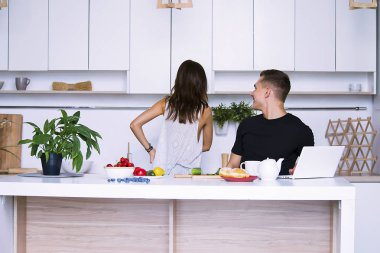 sevimli genç kadın ve erkekte tablo içinde ev yakınındaki beyaz mutfak