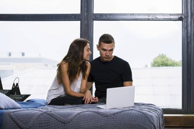 sevimli kadın ve erkek birlikte dizüstü Oda penceresinde yakınındaki izlerken