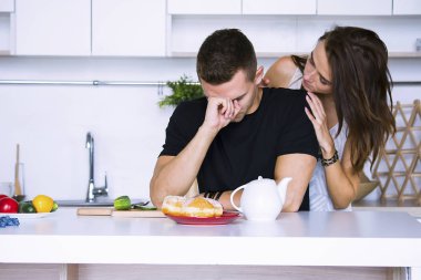 güzel bir kadın bir erkek beyaz mutfak yatıştırır