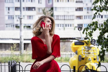 sevimli kız tarafından cep telefonu açık havada şehirde yaz aylarında konuşuyor