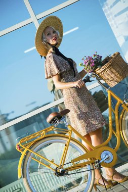 şapkalı şirin kız yaz aylarında açık havada bir şehirde retro bisikletle seyahat