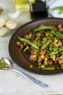 Kızarmış etli sebze ve bir plaka üzerinde baharatlar ile kuşkonmaz