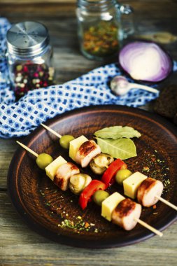 peynir ve bir tahta şiş üzerinde sebzeli mantar ile kızarmış sosis